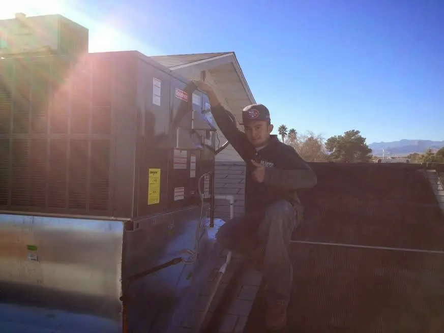 HVAC technician performing Boiler Repair on a rooftop unit in Lemay